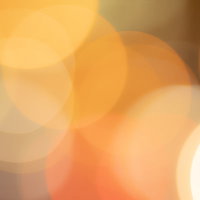 輝くオレンジ色の丸ボケとライトアップの光の写真