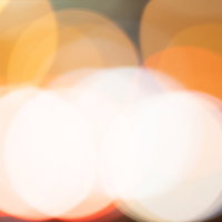 オレンジ色の丸ボケが広がる光の背景の写真