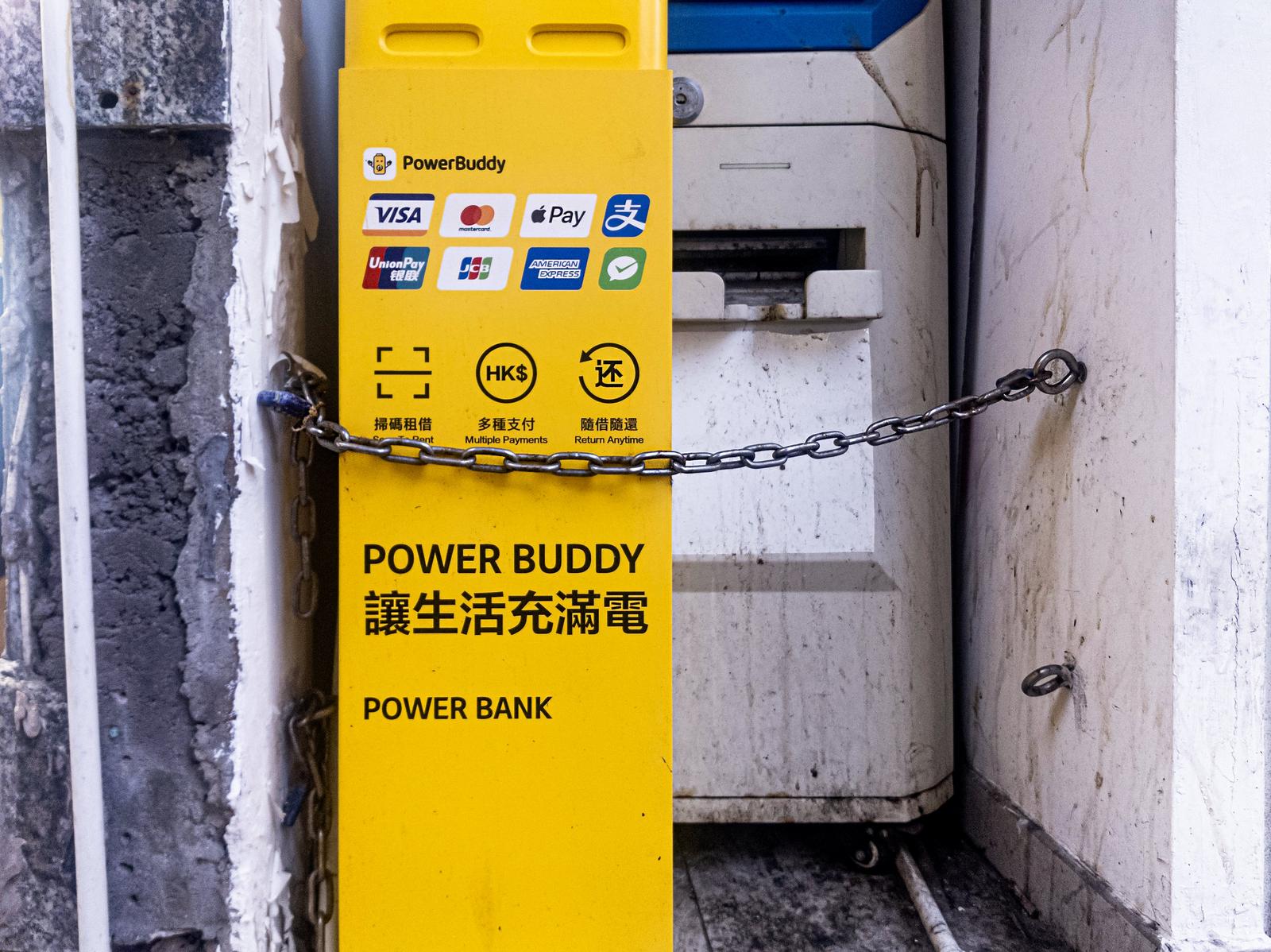 チェーンで塞がれた黄色いPowerBuddy暗号通貨ATM機器の正面アップ