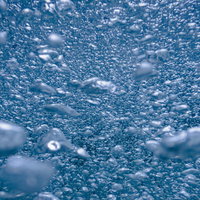 青い水中に浮かぶ無数の気泡がブクブクと立ち上るの写真