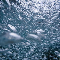 水中で沸き立つ無数の気泡のテクスチャーの写真