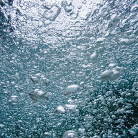 水中のぶくぶく気泡が光に輝くテクスチャーの写真