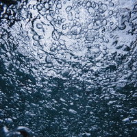 水中の一面に広がる気泡のテクスチャーの写真