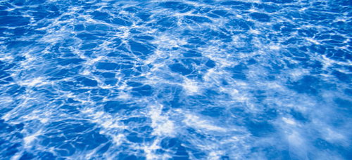 プール底の水面に映る太陽光の光跡テクスチャー
