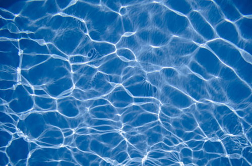 プールの水中に広がる太陽光の屈折による光の斑模様