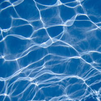 プールの水中に広がる光の斑模様のテクスチャーの写真