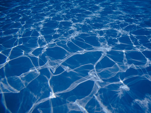 プールの水中を走る光の斑模様と波紋のテクスチャー
