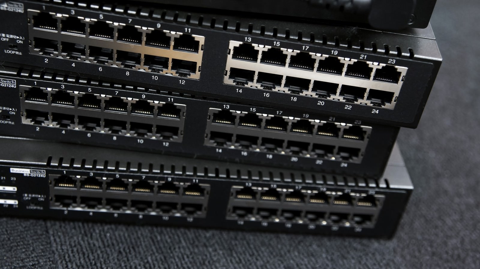 多数のLANポートが並ぶ黒色のネットワークスイッチ機器の重ね置き