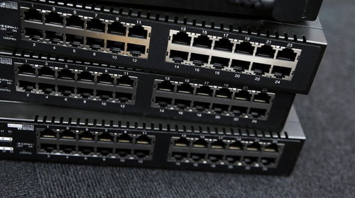 多数のLANポートが並ぶ黒色のネットワークスイッチ機器の重ね置き