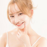 歯を見せて笑顔で微笑むスキンケア女子の美肌ポートレートの写真