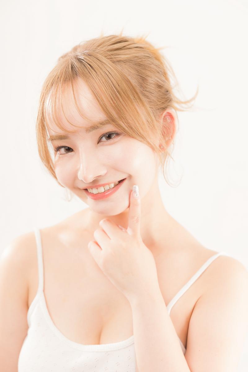 歯を見せて笑顔で微笑むスキンケア女子、白いタンクトップ姿［モデル：yuria］