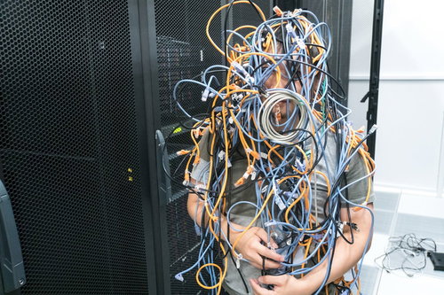 大量のLANケーブルに埋もれるマン
