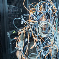 ぐちゃぐちゃに絡まるLANケーブルの通信障害の写真