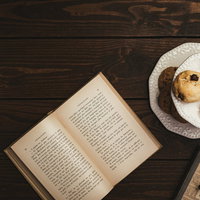 テーブルに置かれた洋書とクッキーでティータイムの写真