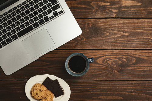 ティータイムのおやつとコーヒーを楽しむ木目のテーブル