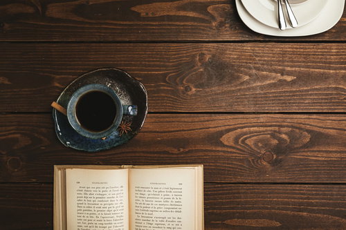 喫茶店のテーブルに置かれた洋書とブラックコーヒー