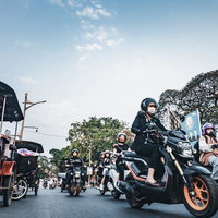 東南アジアの交通渋滞でヘルメットを着用してバイクに乗る人々の写真