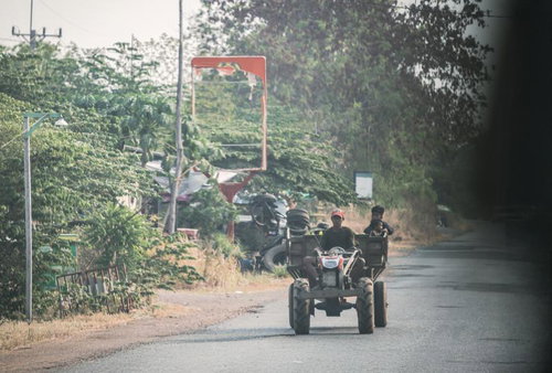 カンボジア風の田舎道を走るトラクター