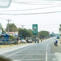 カンボジア風の農村集落と赤土道路の写真