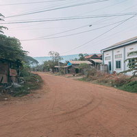カンボジアの田舎町で民家が立ち並ぶ住宅街の赤土道路の写真