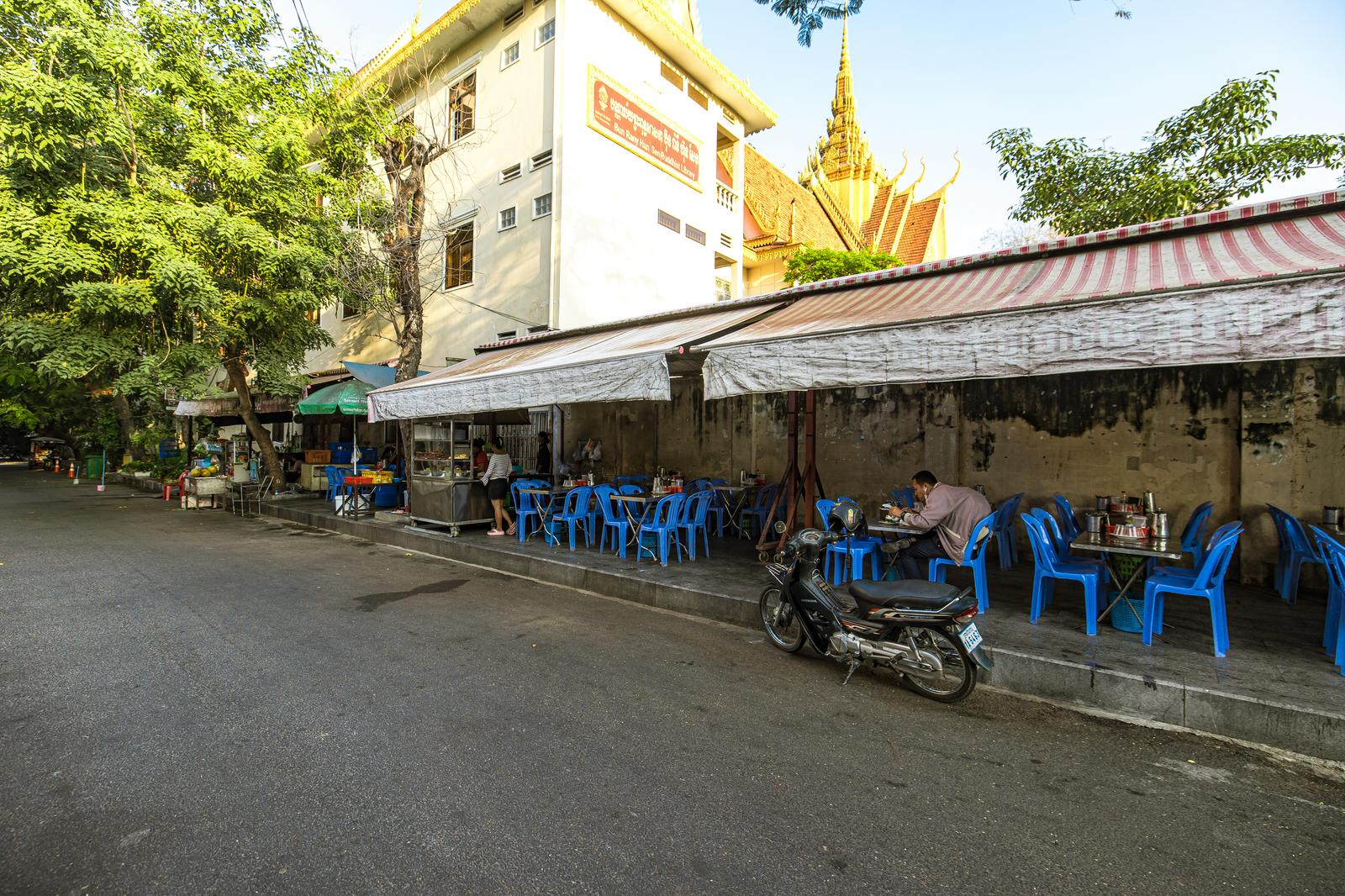 舗装道路を走る農業用トラクターと運転手