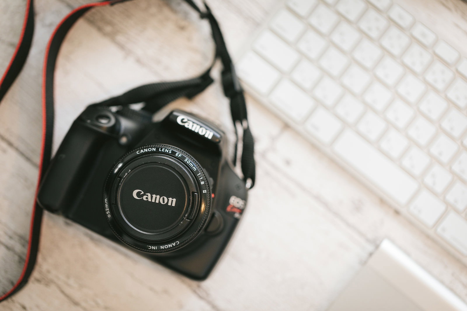 白い机の上に置かれたCanonの一眼レフカメラ