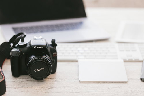 デスクに置かれたパソコンと一眼レフカメラ