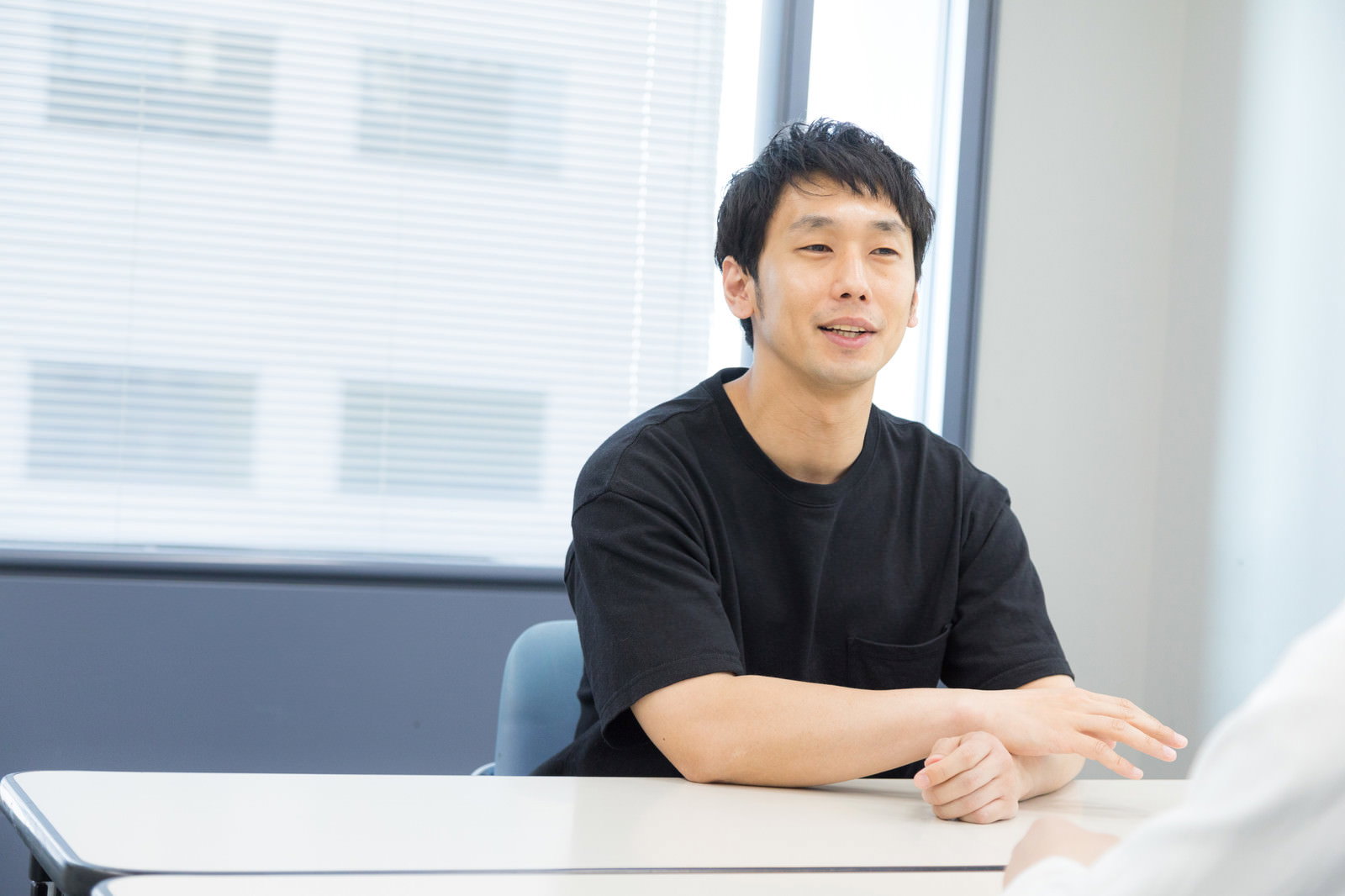 会議室でインタビューを受ける笑顔の男性タレント［モデル：大川竜弥］