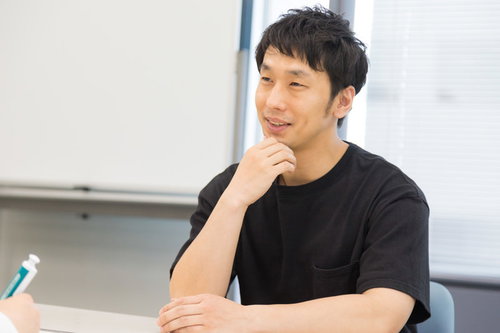 ろくろ回し中のインタビューに答える陶芸職人の男性