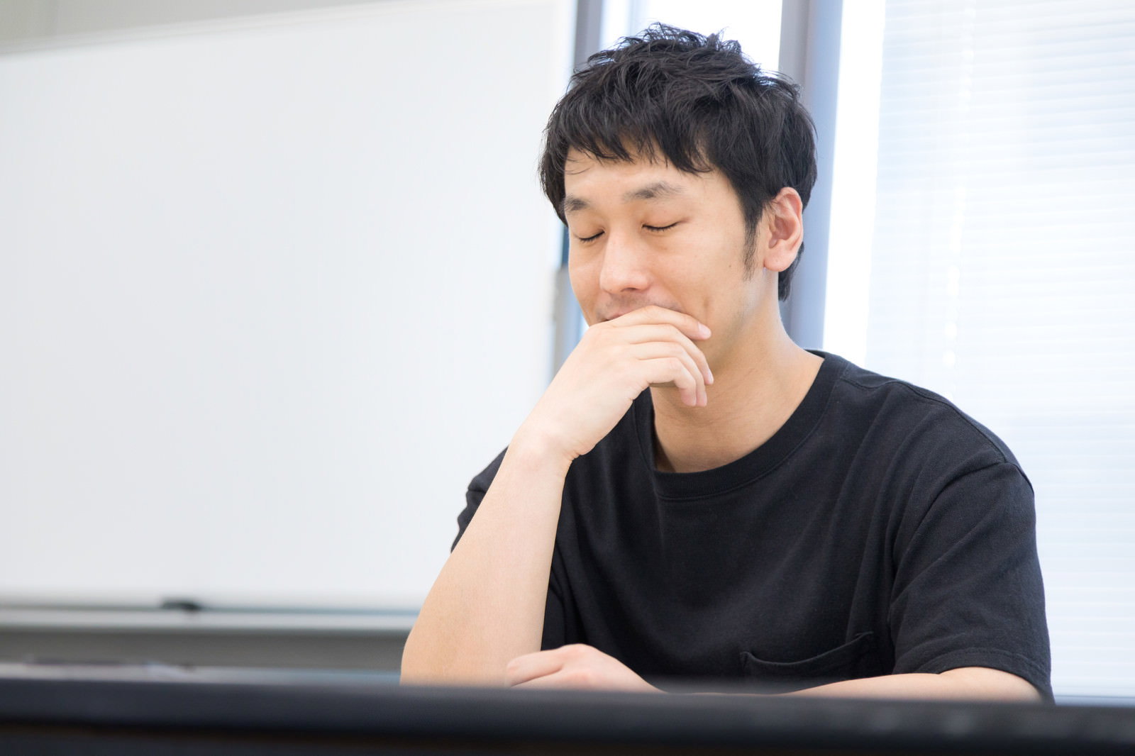質問に答えられず手を顔に当てて困った表情を見せる男性［モデル：大川竜弥］