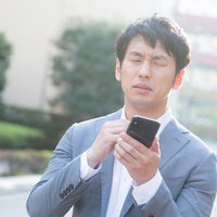 突然の修正依頼メールに驚きを隠せないエンジニア男性の写真