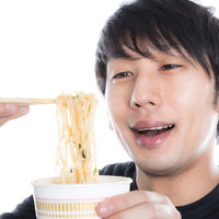 カップラーメン大好きっ子の男性がおいしそうに食べている様子の写真