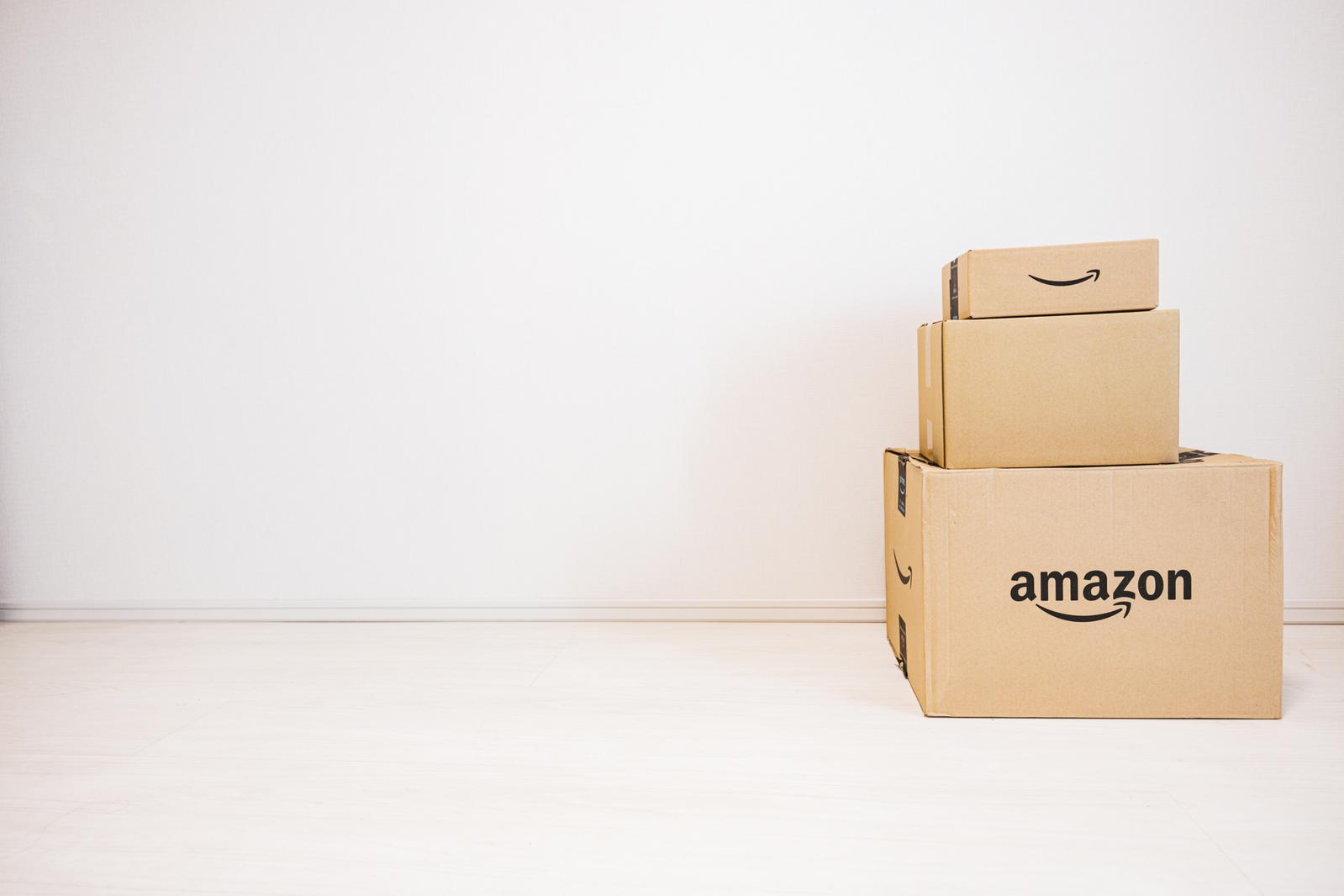 アマゾンのロゴが印字されたダンボール箱を積み重ねた配送梱包