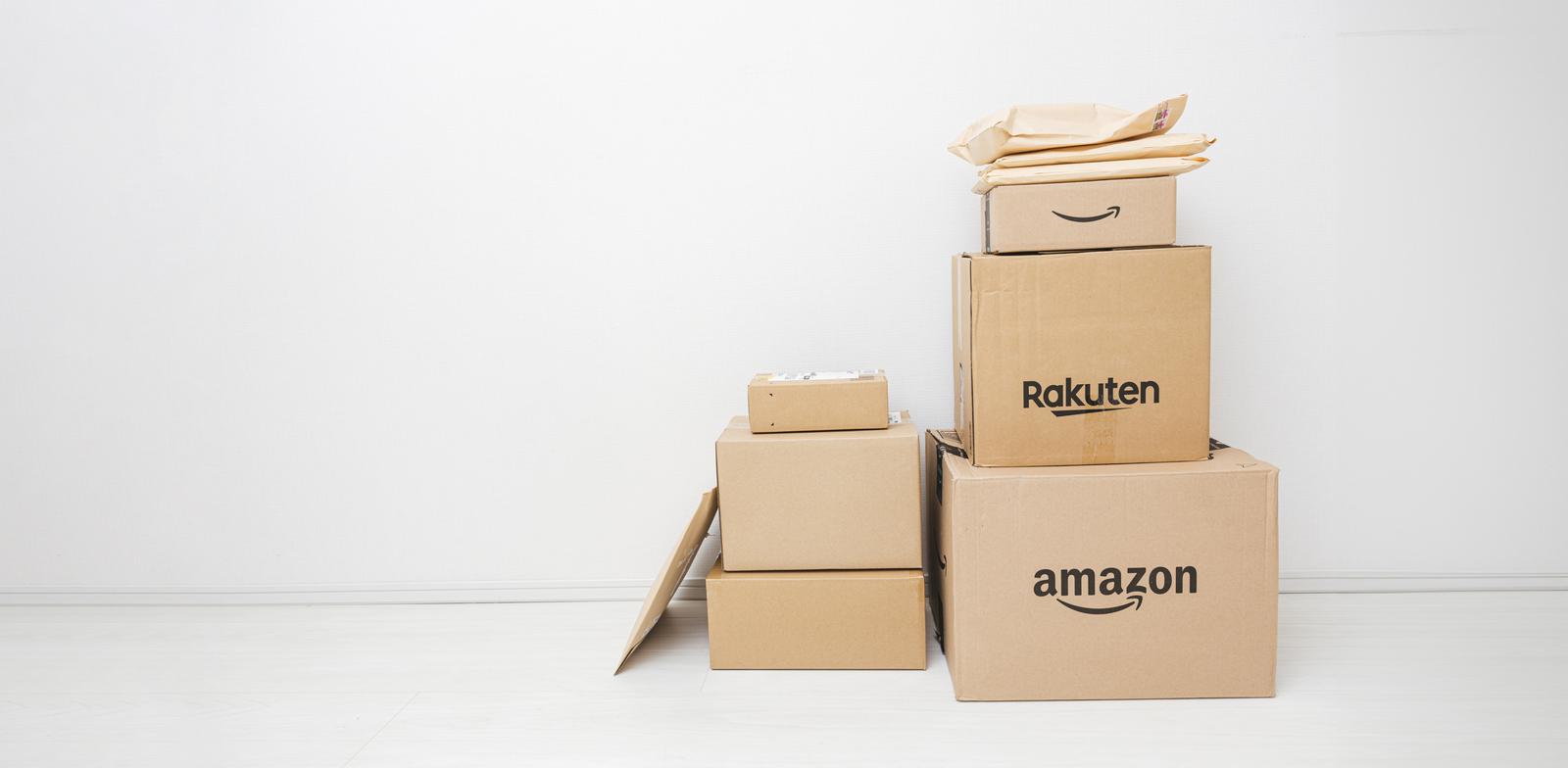 AmazonとRakutenのロゴが入ったダンボール箱を積み重ねた様子