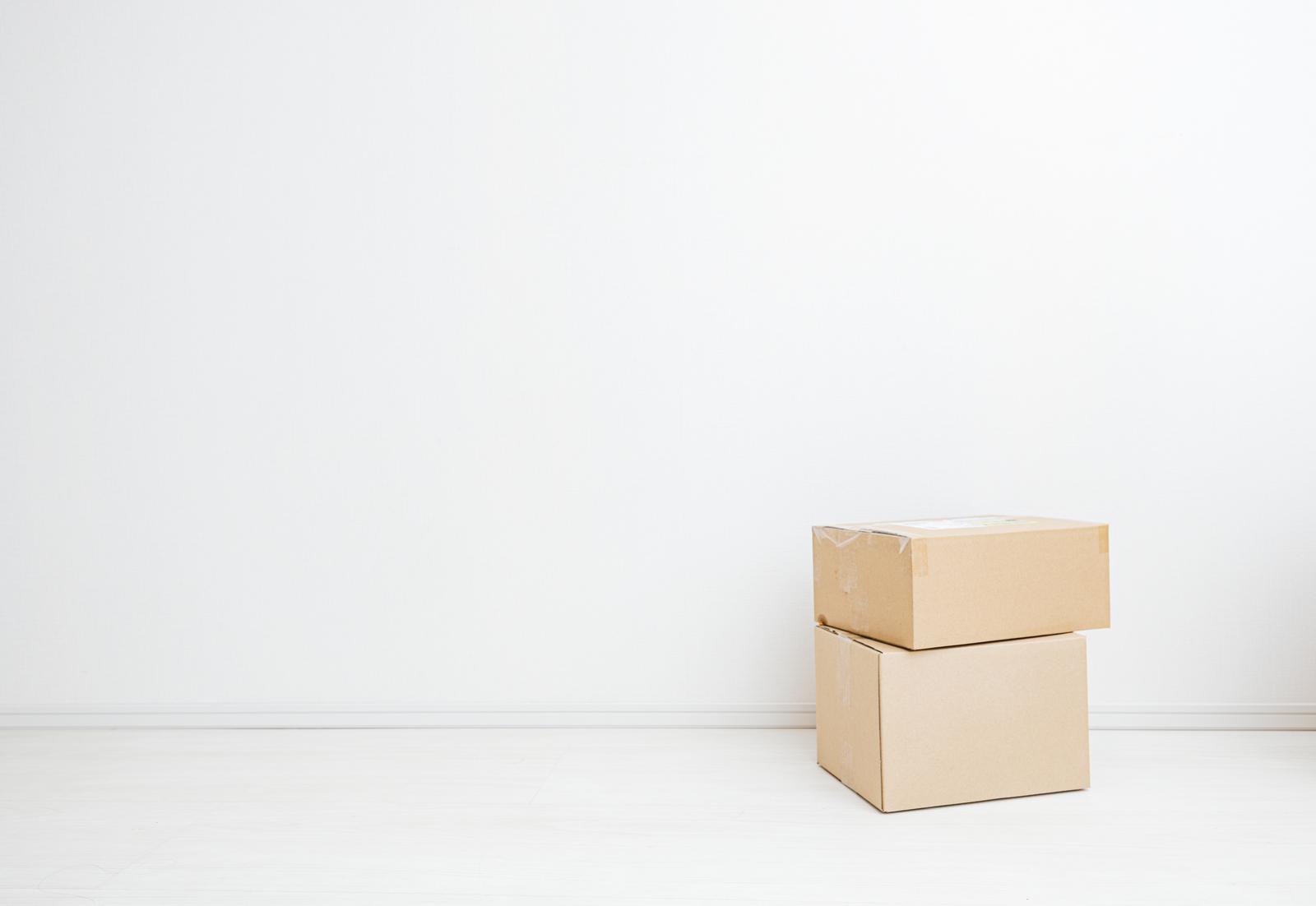 白い部屋に積み重ねられたふたつのダンボール箱