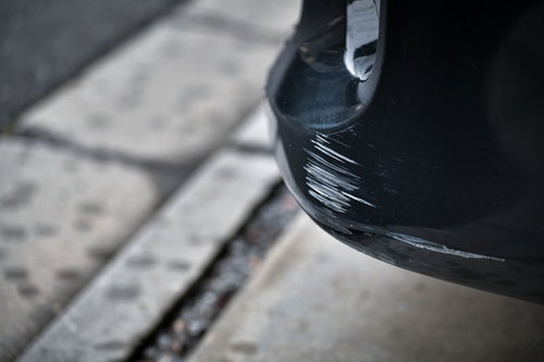 黒い車のバンパーを傷つけてしまった事故後の状況