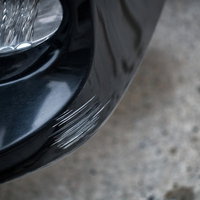 黒い車のバンパーについた白い擦り傷と損傷状況の写真