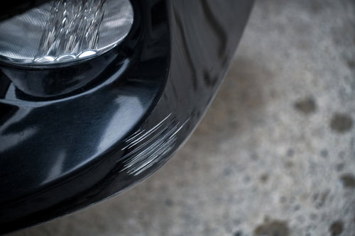 黒い車のバンパーについた白い擦り傷と損傷状況