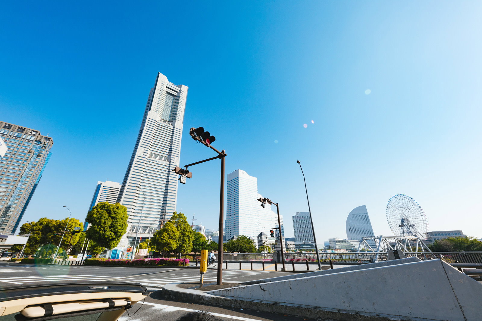 青空の下、横浜みなとみらいの景色を背景に走るオープンカー