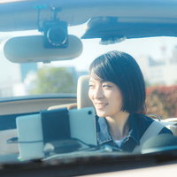 オープンカーの助手席で微笑む彼女との昼間のドライブの写真