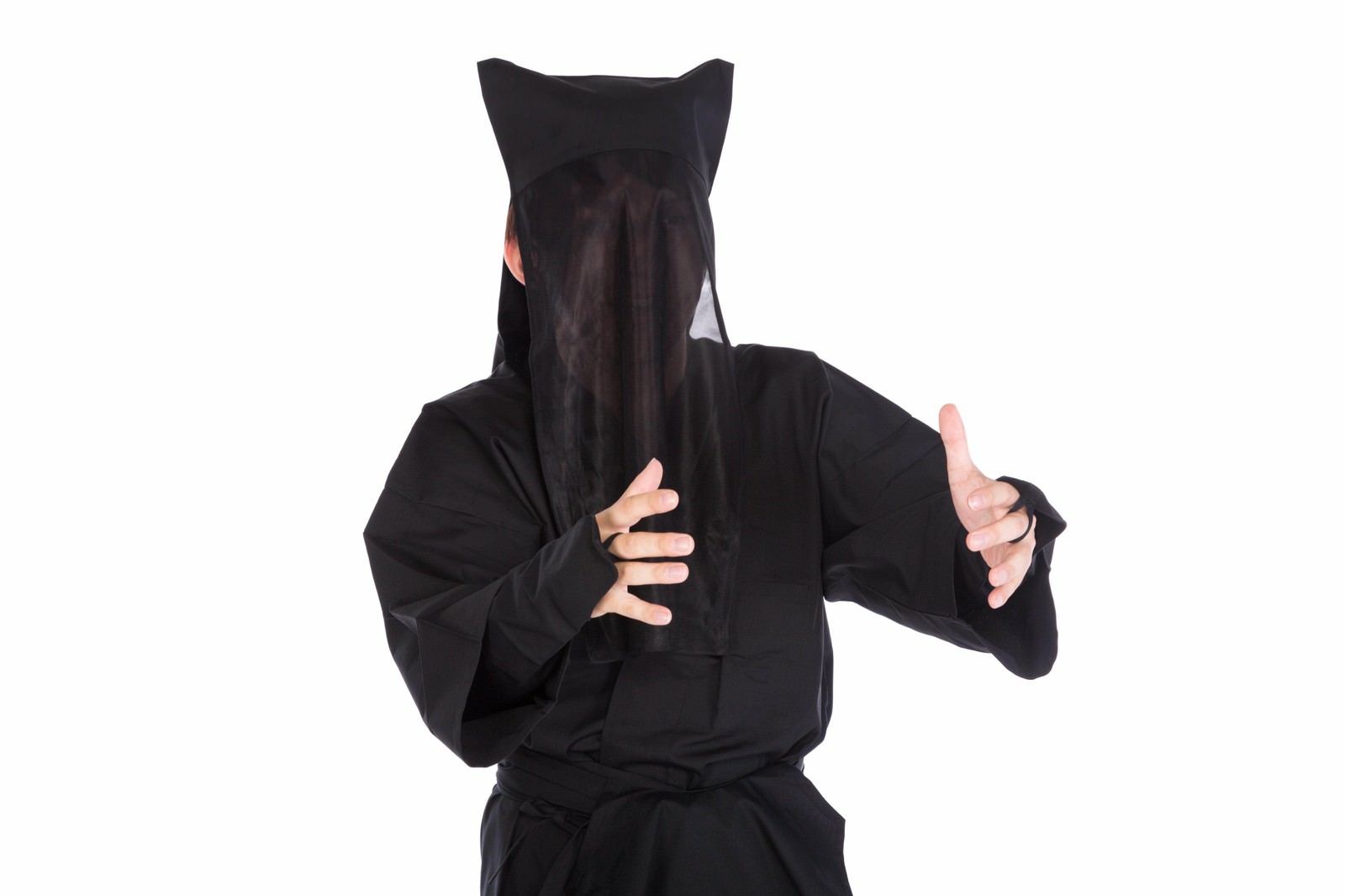 黒い衣装を着た顔が見えない人物が、両手を広げるジェスチャーをしている［モデル：鈴木秀］