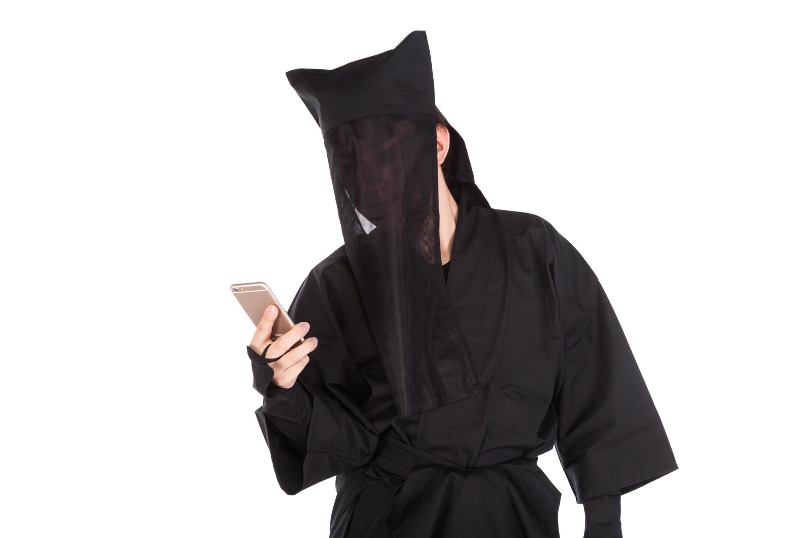 黒い衣装で顔全体を覆うネット付きの被り物をかぶり、ゴールド色のスマートフォンを手に持つ人物［モデル：鈴木秀］