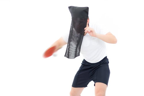 黒子姿で卓球のサーブを打つ男性