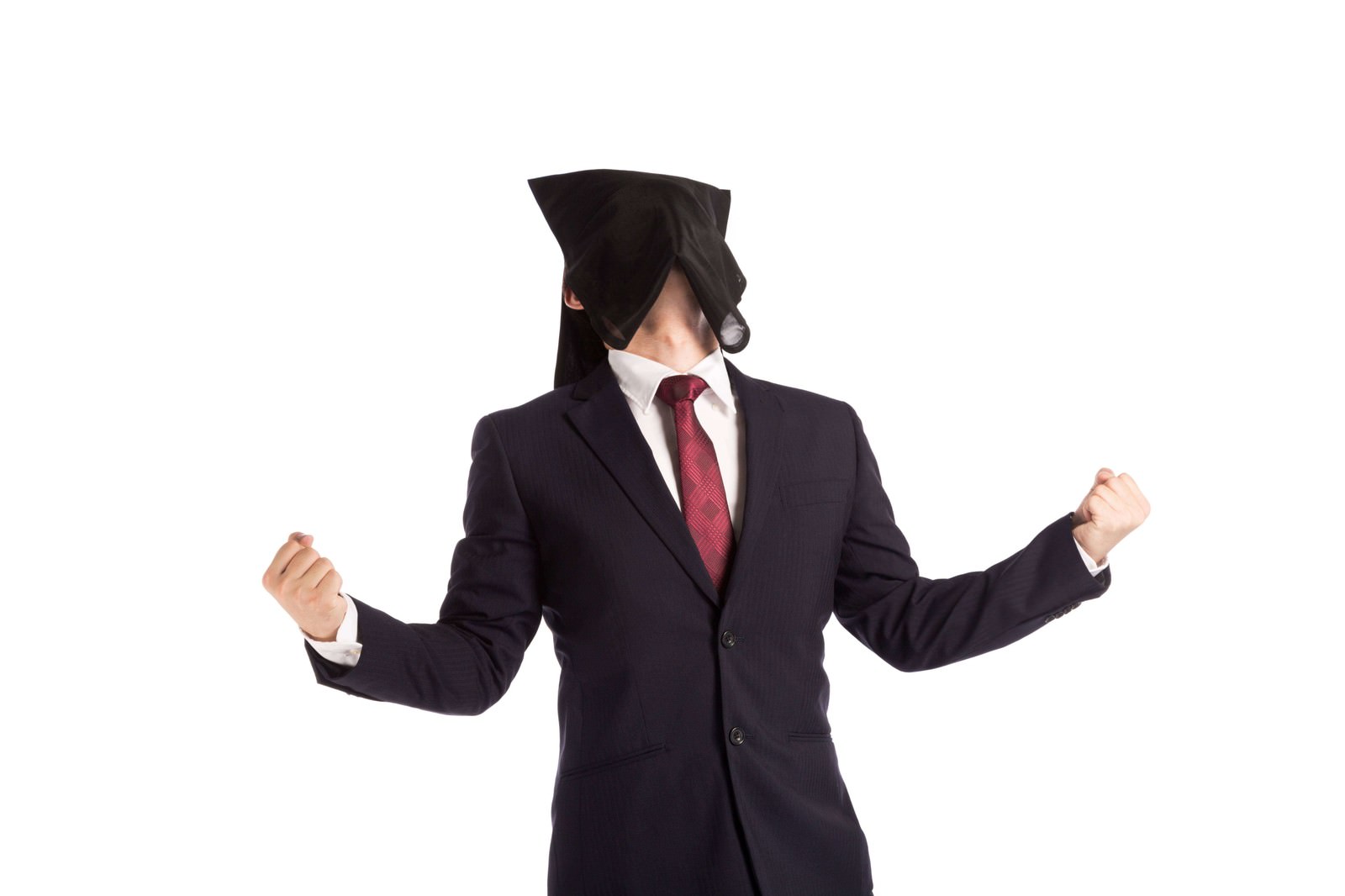 黒い帽子と黒スーツを着た男性が両拳を握った力強い姿勢で気合を入れている［モデル：鈴木秀］
