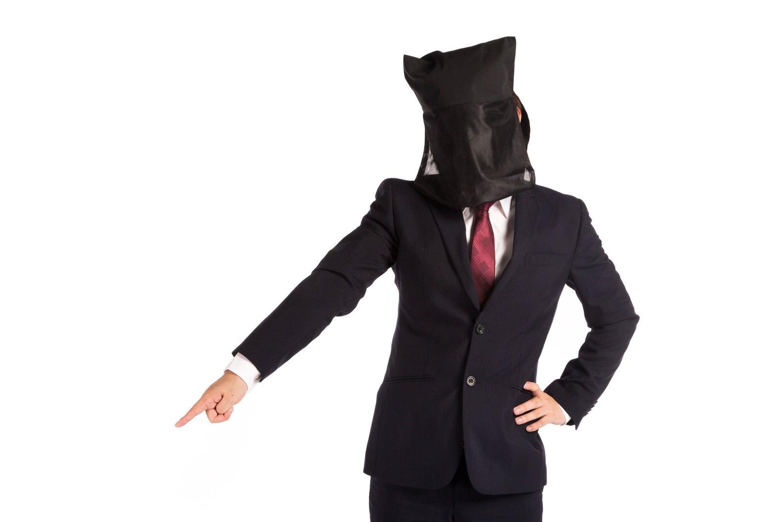黒い布をかぶった紺スーツの人物が左手で指差しながら立つ［モデル：鈴木秀］