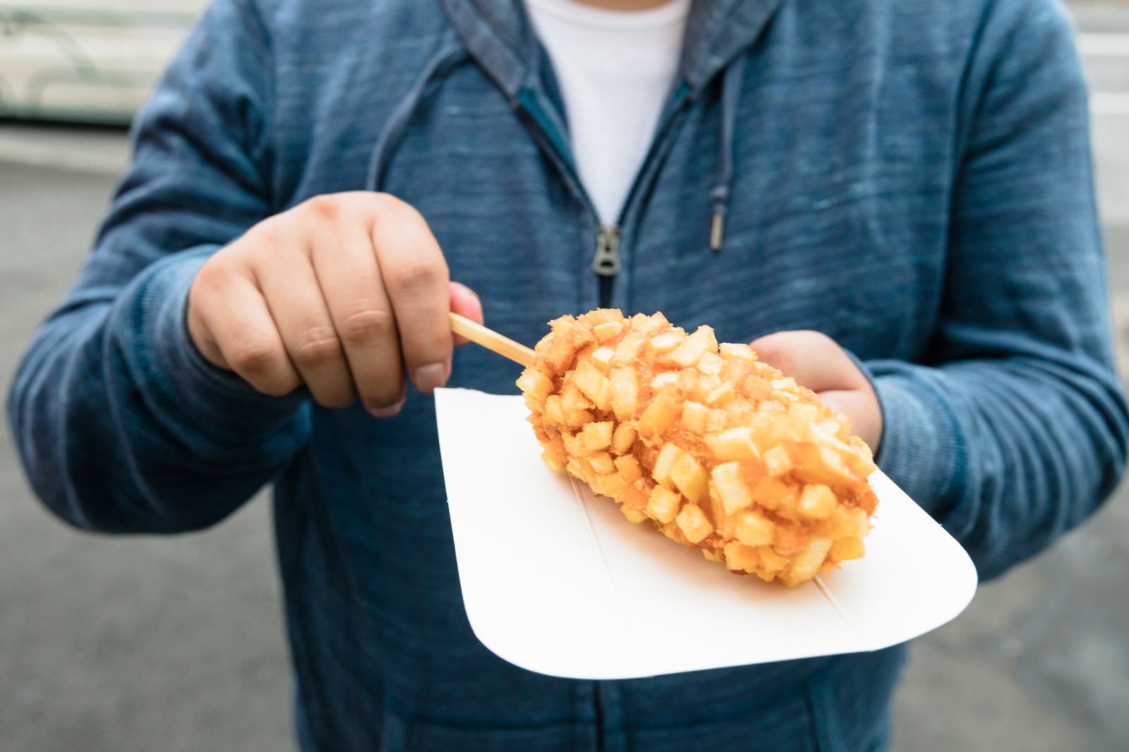 チーズドッグを手持ちする男性