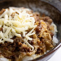 白玉ねぎトッピングのチーズ乗せ牛丼の高カロリー丼ぶりの写真