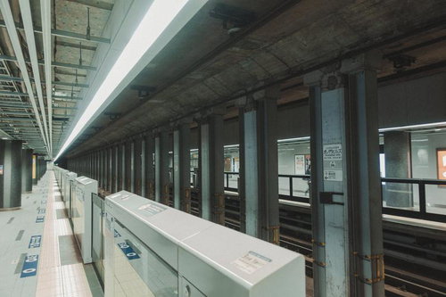 静かな虎ノ門ヒルズ駅のコンクリート柱が並ぶホーム