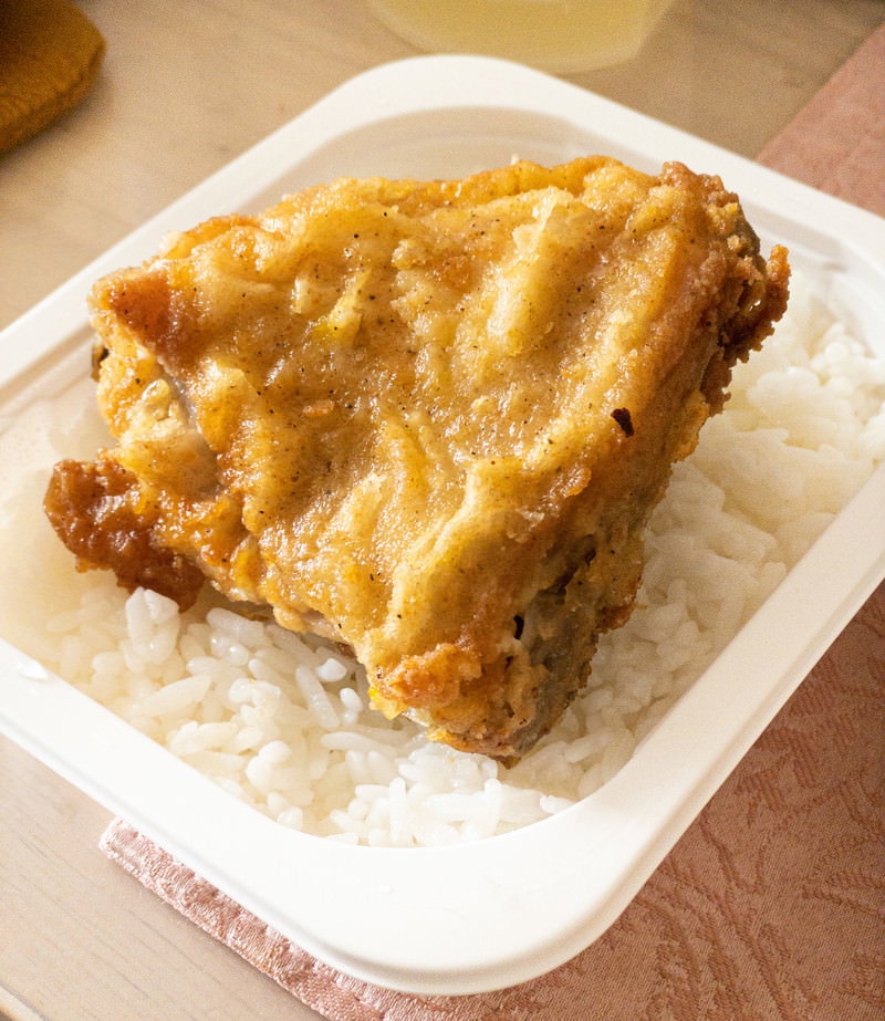 白いプラスチック容器に盛られたレンチンご飯とフライドチキン