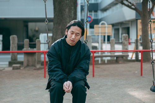 リストラされて公園のブランコで項垂れるアラフォー男性